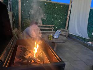 a man is cooking over a fire on a patio at Nómadas Hostel in La Paz