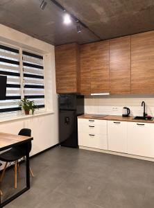 eine Küche mit Holzschränken, einem Tisch und einem Esszimmer in der Unterkunft Loft на Кониського, центр in Dnipro