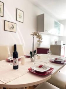 uma mesa com uma garrafa de vinho e copos em Apartman Dorja em Fažana
