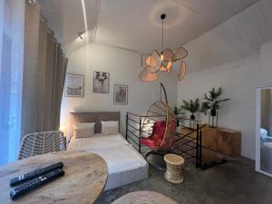 a bedroom with a bed and a table and a chandelier at Apartamenty Prosta - Podmurna in Toruń
