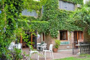 un patio con mesas y sillas frente a un edificio en Hostel Posada Juan Ignacio en Rosario