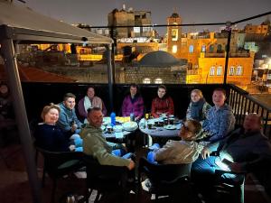 a group of people sitting at a table on a roof at New Citadel Hostel in Jerusalem