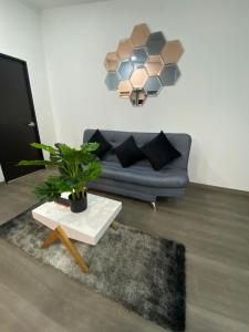 ein Wohnzimmer mit einem Sofa und einem Tisch mit einer Pflanze in der Unterkunft Hotel Hostal Caps El Poblado in Medellín