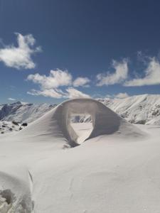 un montículo de nieve sobre una montaña cubierta de nieve en RezoHut en Gudauri