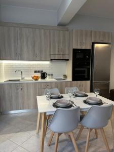 uma cozinha com uma mesa branca com cadeiras e um frigorífico em Little Nest - Luxury Living em Cidade de Kos