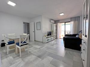 uma sala de estar com uma mesa e um sofá em Apartamento Carihuela Beach Experience em Torremolinos