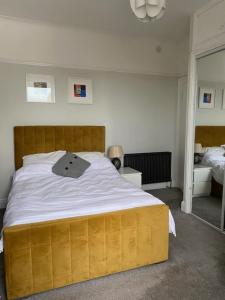 a bedroom with a large bed with a wooden headboard at Central en-suite double room in Plymouth