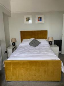 a bedroom with a large bed with a wooden headboard at Central en-suite double room in Plymouth