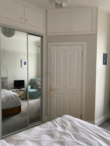 ein Schlafzimmer mit einem Spiegel, einem Bett und einer Tür in der Unterkunft Central en-suite double room in Plymouth