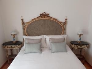 1 dormitorio con 1 cama blanca grande y 2 mesas en Apartamento Onda Azul, en Vila Praia de Âncora