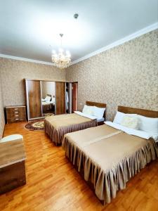 a hotel room with two beds and a chandelier at Asem Hotel in Nukus