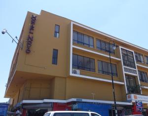 un edificio amarillo con un cartel en el costado en Hotel Novo en San José