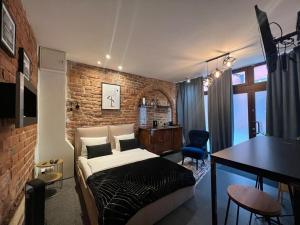 a bedroom with a bed and a brick wall at Apartamenty Prosta & Podmurna z klimatyzacją in Toruń