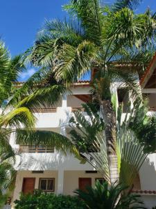 a building with palm trees in front of it at Residencial Paraiso Bayahibe in Bayahibe