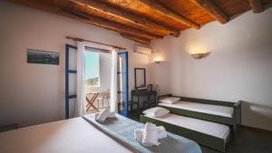 a room with three beds and a window at Villa Niki in Loutro
