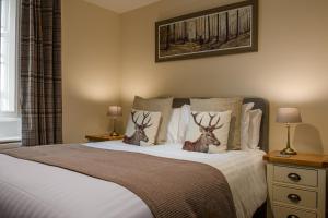 a bedroom with a bed with two deer heads on it at Harts Head Hotel in Settle