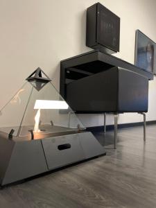 a glass table with a tv on top of it at Cinecittà Luxury GUEST HOUSE in Rome