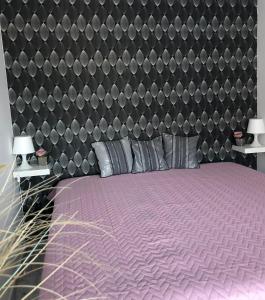 una camera con un letto viola e una grande testiera del letto di Agnes Apartman a Latschach