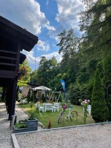 un jardín con una mesa de picnic y una bicicleta en Cezar Dom Wczasowy en Ruciane-Nida