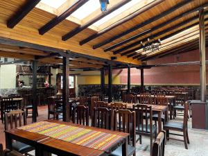 an empty restaurant with wooden tables and chairs at Hostería La Condesa in Honorato Vásquez