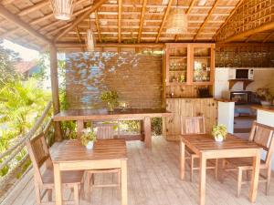 an outdoor kitchen with wooden tables and chairs at Pousada Vila Dendê in Trancoso
