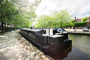 a boat is docked on a river in a city at The Vätten Hüs A Luxury/VIP boat in Manchester