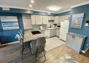 a kitchen with white appliances and a blue wall at Marylander Condominiums, 90 steps from the beach in Ocean City