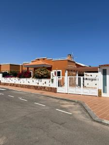 een wit hek aan de kant van een straat bij Casa Piedra, Luxury Family Front Line Golf, Hot Tub,Pool Table, 8 pers, Caleta de Fuste in Caleta De Fuste