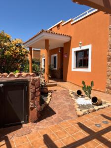 a house with a driveway and a garage at Casa Piedra, Luxury Family Front Line Golf, Hot Tub,Pool Table, 8 pers, Caleta de Fuste in Caleta De Fuste