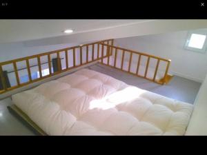 een groot wit bed in een kamer met een trap bij Chez Lulu in Montreuil
