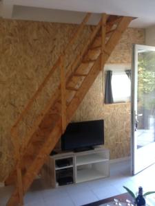 een woonkamer met een tv en een houten trap bij Chez Lulu in Montreuil