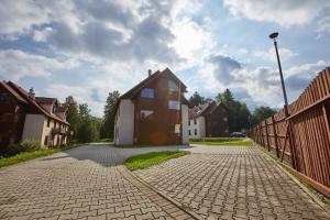 dom na ceglanej drodze obok ogrodzenia w obiekcie APARTAMENTY NAD ŁOMNICZKĄ-MALACHIT w mieście Karpacz