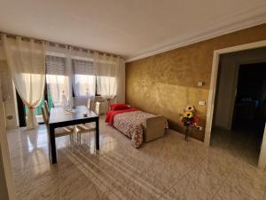 Schlafzimmer mit einem Bett, einem Tisch und einem Schreibtisch in der Unterkunft Appartamento Divino Tramonto in Altedo