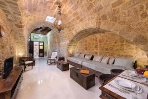 uma sala de estar com um sofá numa parede de pedra em Studio Astero in Ilha de Rhodes
