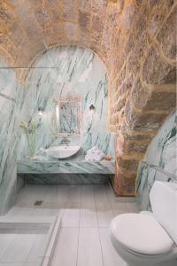 baño con lavabo y aseo en una pared de piedra. en Studio Astero, en Rodas 22 fotos más
