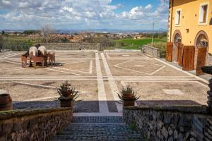 ein Parkplatz mit Tischen und Stühlen und ein Gebäude in der Unterkunft Tenuta Borsari in Frascati