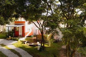 a house with a yard with trees in front of it at Minicasa Brasileira in Sorocaba