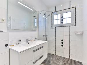 uma casa de banho branca com um lavatório e um chuveiro em Les Sables d’Olonne, Villa**** à 250m de la mer em La Chaume