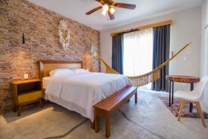 um quarto com uma cama e uma parede de tijolos em Jaakbal Tulum em Tulum
