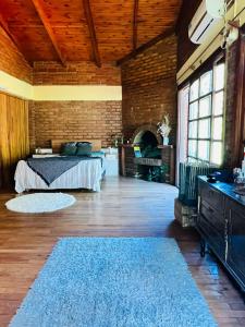 um quarto com uma cama e uma parede de tijolos em Casa de Campo La Olivia em Eldorado