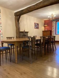 a dining room with a wooden table and chairs at La Futaie de Chabrehez- maison typique ardennaise in Houffalize