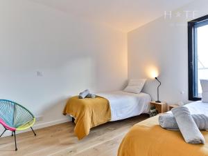 um quarto com 2 camas e uma cadeira em Les Sables d’Olonne, Villa**** à 250m de la mer em La Chaume