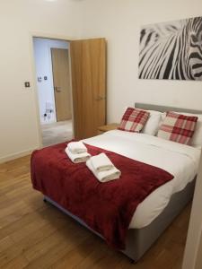 a bedroom with a large bed with towels on it at Modern 2BD2Bath Apart CityCentre in Glasgow