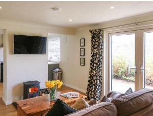 a living room with a couch and a tv at Shoemaker's Rest 