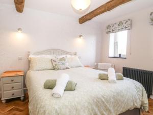 sypialnia z dużym łóżkiem z białą pościelą i poduszkami w obiekcie Pip's Barn w mieście Brynteg