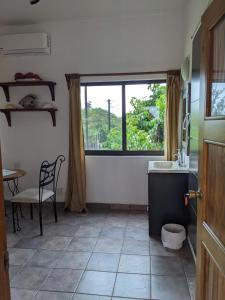 kuchnia ze zlewem, stołem i oknem w obiekcie Hacienda De Palmas w mieście La Ribera
