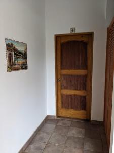 Habitación con puerta de madera y una foto en la pared. en Hacienda De Palmas en La Ribera
