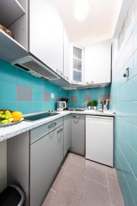 布拉格Bohéme Apartment Wenceslas Square的厨房设有蓝色的墙壁和白色的橱柜。