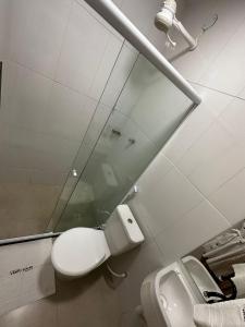 a bathroom with a toilet and a mirror and a sink at Pousada Vento Solar Búzios in Búzios