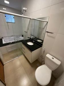 a bathroom with a white toilet and a sink at Pousada Vento Solar Búzios in Búzios